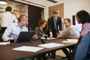 smiling-businesspeople-meeting-together-in-an-office-boardroom-e1640485240853.jpg